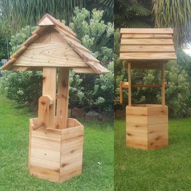 Wooden wishing well planter with a hexagonal slatted box, two posts, crank handle and pitched shingle roof.